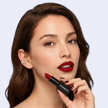 Woman holding a red lipstick with a plain background